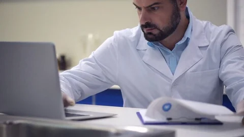 Serious male researcher typing in data while working on laptop Stock Footage 80355780
