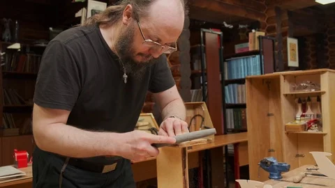 Serious man with beard rasps soviet airplane model detail Stock Footage 127377119
