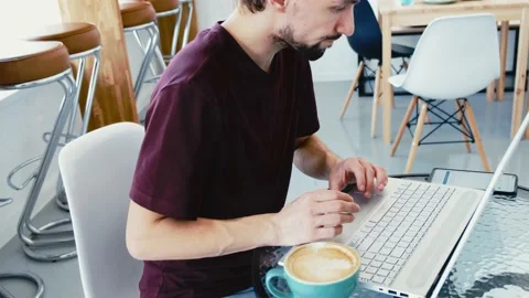Serious man developer in casual wear working remotely in cafe interior using Stock Footage 160052962