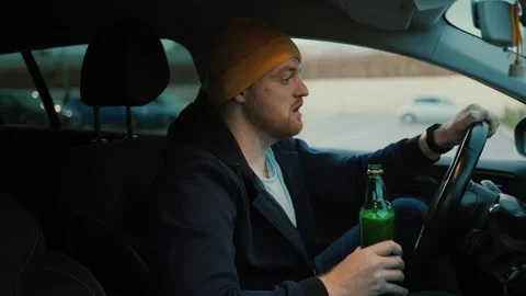 Serious man driver with beer bottle in hand Stock Footage 260074727