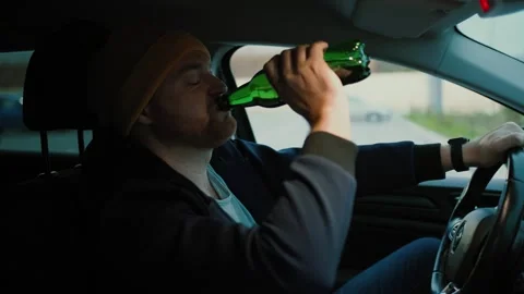 Serious man driver with beer bottle in hand Stock Footage 260074742
