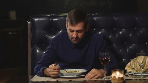 A serious man eats in the restaurant and drinks wine with lunch Stock Footage 70447883
