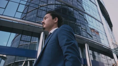 Serious man in an elegant suit walking outside near big corporate office. Stock Footage 163372663