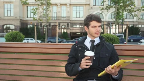 The serious man is examining documents and drinking coffee Stock Footage 311986375