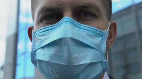 Serious man in facemask looking at camera, concerned about air pollution in city Vídeo Stock 117222333