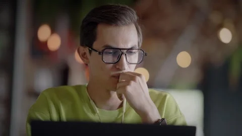 Serious man with glasses is sitting at table with laptop in cafe. Slow motion Stock-Footage 343513161