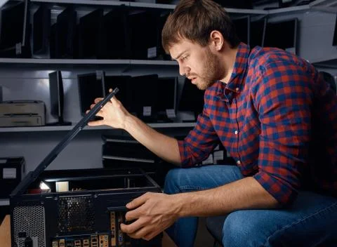 Serious man having problems with system unit Stock Photos
