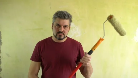 Serious man holding a paint roller in his hands 4K Vídeo Stock 126145508