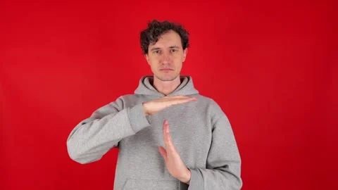Serious man holds hands in front of shows sign timeout gesture. 動画素材 304749397
