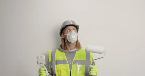 Serious man industrial worker focused above on ceiling holds painting brush and Stock Footage 155862998