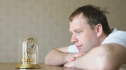 Serious man looks at the table clock with pendulum Stock Footage 62766832