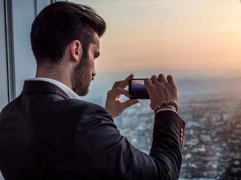Serious man in modern building with cell phone Stock Photos