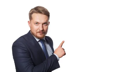 Serious man pointing away while standing against white background Stock Photos