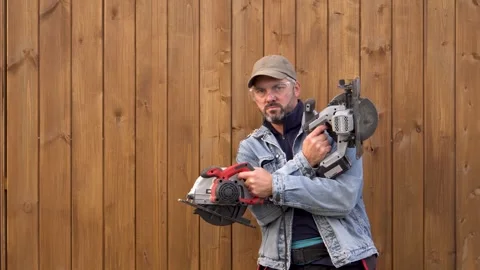 Serious man posing with electric saws 4K Video stock 291268385