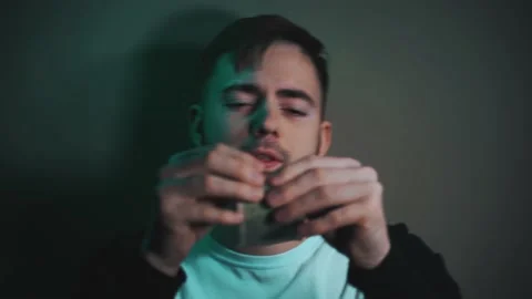 Serious man rolls up dollar bill instead of cigarette Vidéo 147463799