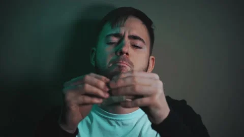 Serious man rolls up dollar bill instead of cigarette Vidéo 147463812