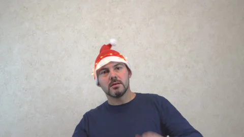 Serious man in santa hat dancing against the wall 4K Stock Footage 142407122