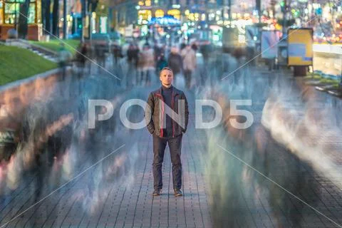The serious man stand in crowd stream. Evening night time Stock Photos