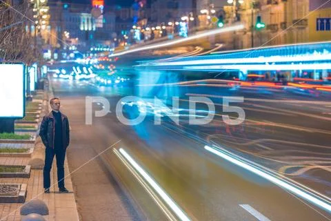 The serious man stand on the roadside against the background of traffic str.. Stock Photos
