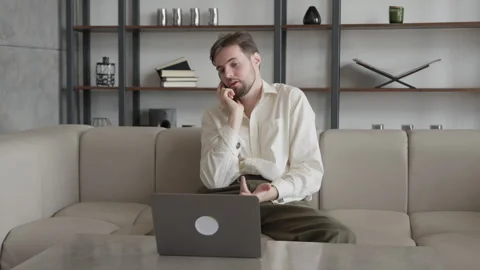 Serious Man Talking On Phone While Working On Laptop In Modern Office Vídeos de archivo 331789368