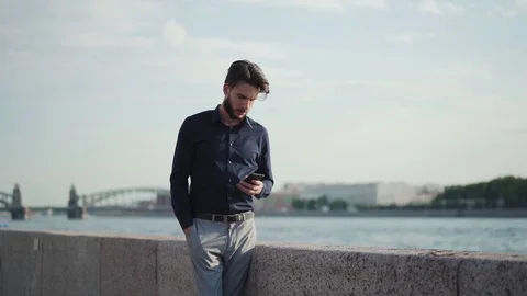 Serious man thinking and texting near river Stock Footage 113697452