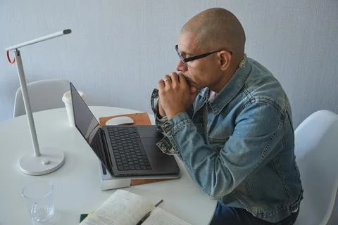 Serious man thinking while working on laptop Stock Photos