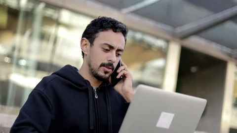 Serious man using laptop and smartphone Stock Footage 125808540