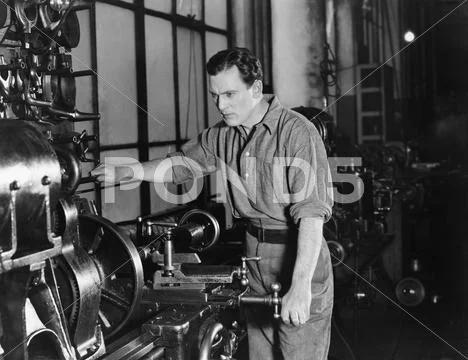 Serious man using large machine Stock Photos