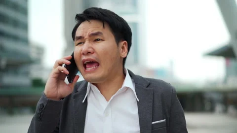 Serious man walking and talking a mobile phone in the city Stock Footage 141902892