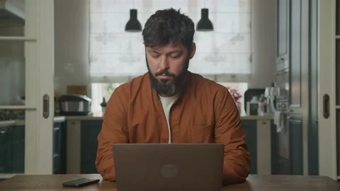 Serious man working on the laptop computer indoors Stockbeeldmateriaal 199306948