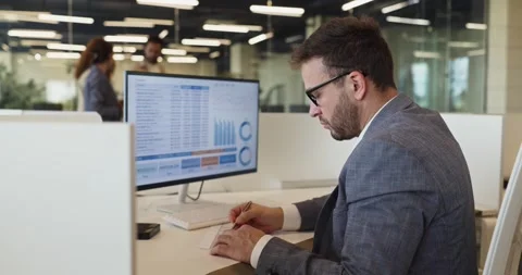 Serious manager analyzing data dashboard and graphs on desktop computer at Stock Footage 340407714