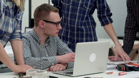 Serious manager in glasses looking at computer and talking to his team Stock Footage 71608522