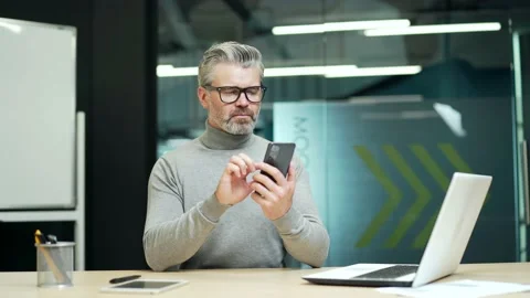 Serious mature gray haired bearded businessman in glasses carefully reading  Stock Footage 232581674