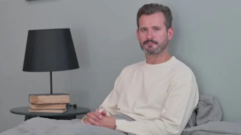 Serious Middle Aged Man Looking at Camera in Bed Stock Footage 287899173