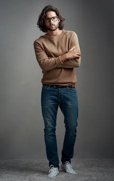 Serious mode - on. Studio shot of a handsome young man posing against a gray Stock Photos
