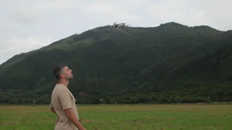 Serious modern man operates complex flying gadgets. Focus on remote control Stock Footage 323054766