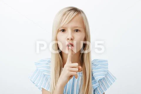 Serious obedient child asks keep voice down, looking after little sister Stock Photos