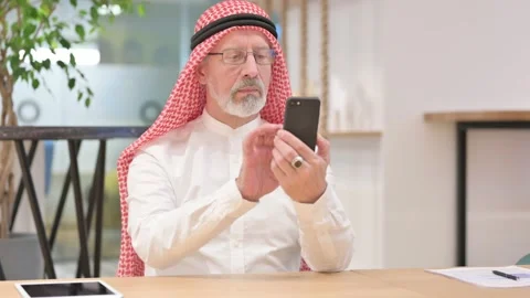 Serious Old Arab Businessman using Smartphone Stock Footage 139776823