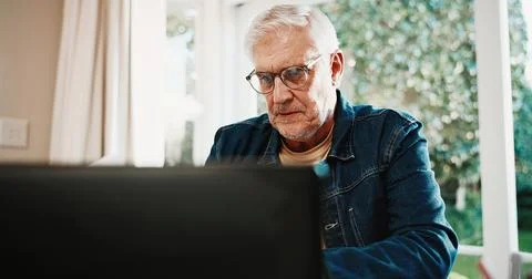 Serious, old man and reading at house with laptop, research and finance mistake Foto stock