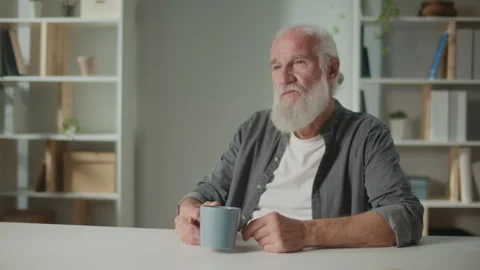 Serious Old Man Sits at the Table and with a Cup of Coffee. Stock Footage 244961562