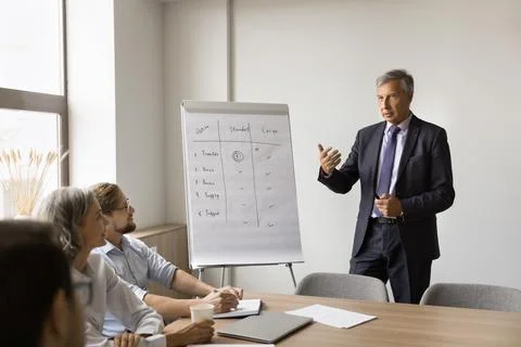 Serious older director man speaking to business team Stock Photos