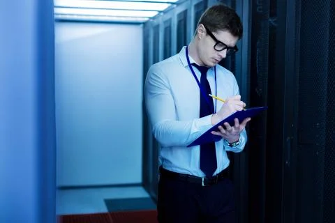 Serious operator taking important notes Stock Photos