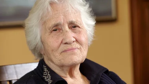 Serious pensive old lady looking at camera - indoors Stock Footage 129757562
