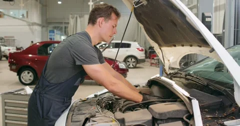 Serious pensive thoughtful mechanic cannot repair car, solve problem of vehicle Stock-Footage 257062839