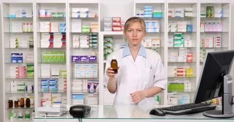 Serious Pharmacist Looking Camera Thumb Up Sign Gesture Promoting Bottle Syrup Stock Footage 72765321