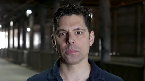 Serious portrait of man staring into camera - under bridge. Stock Footage 106141331