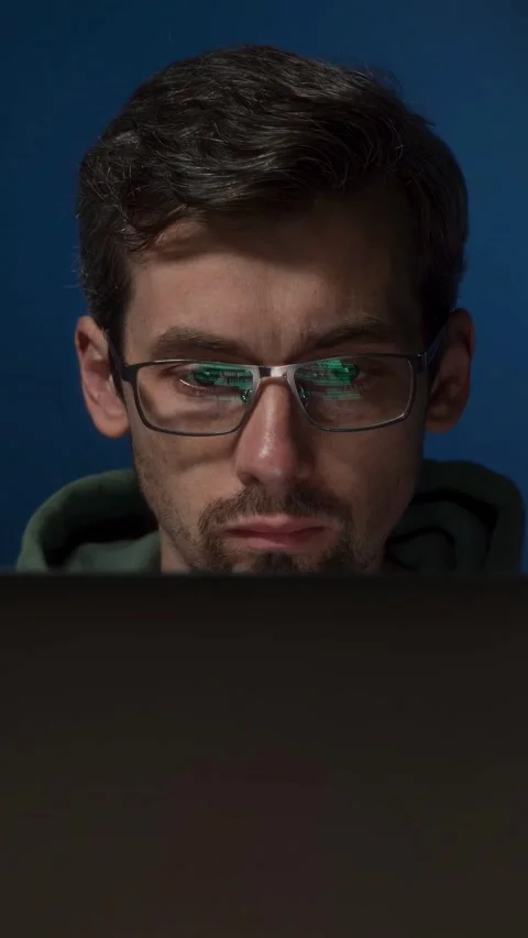 Serious programmer wearing glasses, with green code reflecting on his lenses Stock-Footage 303998390