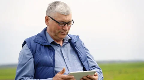 Serious senior look on a camera but doesn`t stop to search something  Stock Footage 63373656