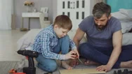 Serious Small Boy Is Concentrated On Putting Screw In Pieces Of Wood With Stock Footage