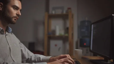 Serious software developer writing a programming code at night Stock Footage 75015078